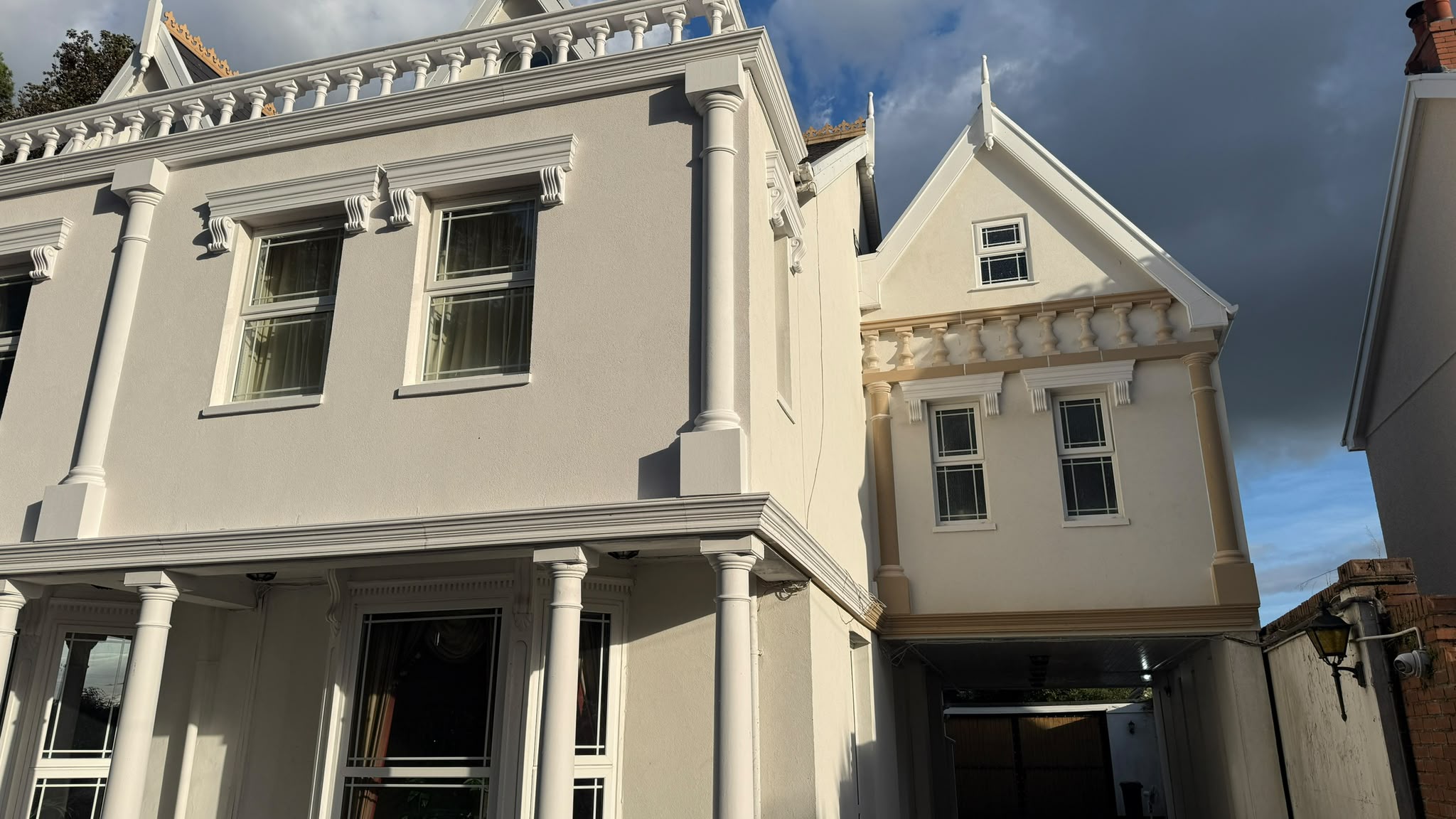 House in Neath with exterior banding and window heads, painted on the left, buff sandstone on the right